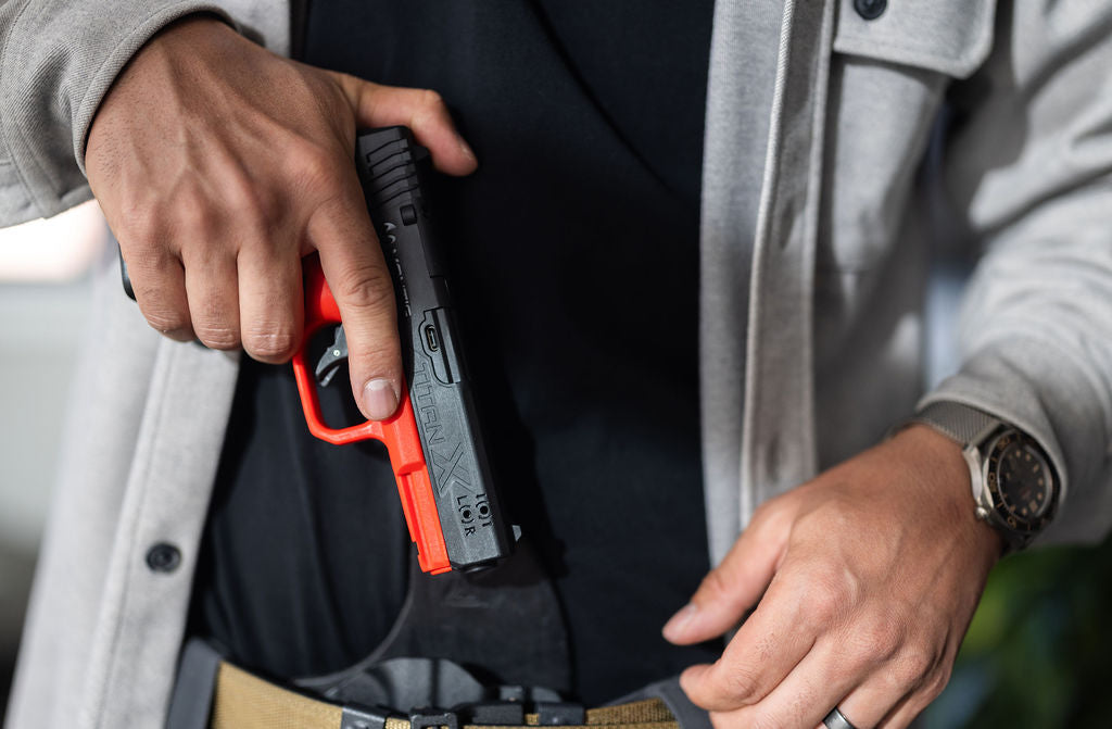 Shooter drawing a red and black Mantis TitanX inert training pistol