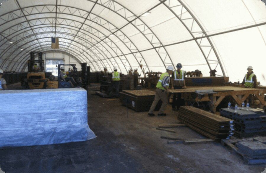 Crew fabricating precast ballistic concrete panels inside a covered production facility