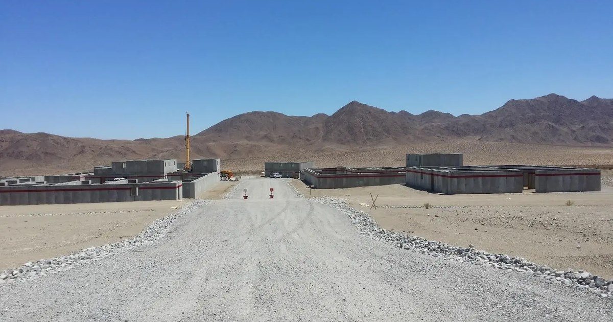 Precast live-fire training structures on a desert range complex, with a crane still on site