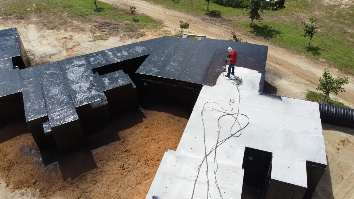 Waterproofing being applied to precast roof panels on a subterranean training complex
